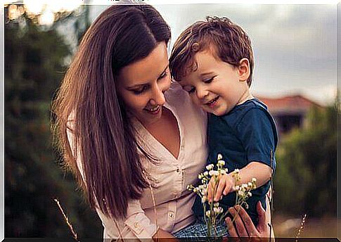 Mother and child look at a flower