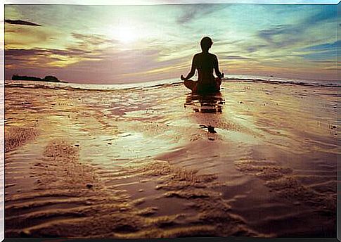 Meditating woman on the beach