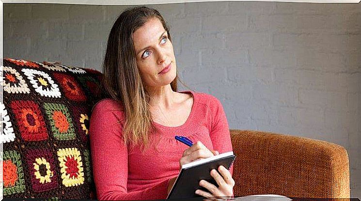 Woman thinks about what to write on her pad