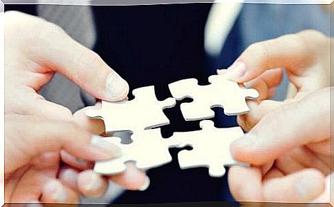 Four people are holding pieces of the puzzle together.