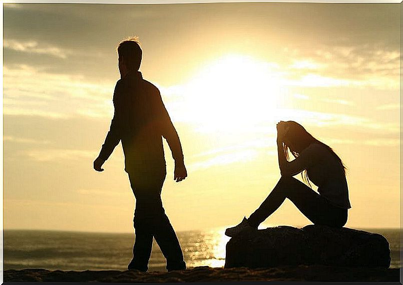 Quarreled couple on the beach at sunset