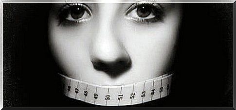 Stop anorexia - woman with measuring tape in front of her mouth