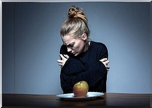 Woman with inappropriate body image in front of apple