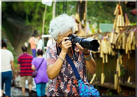 An elderly woman takes photos. 