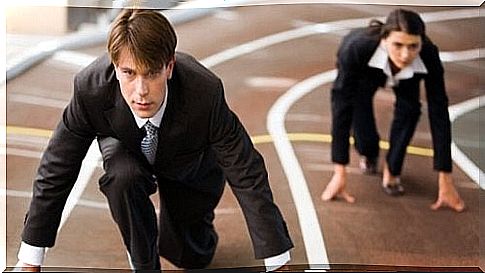 A man and woman in suits are ready for a race.