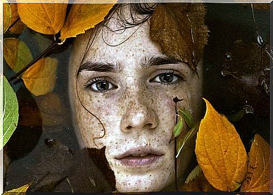 Face of a boy looking out of foliage