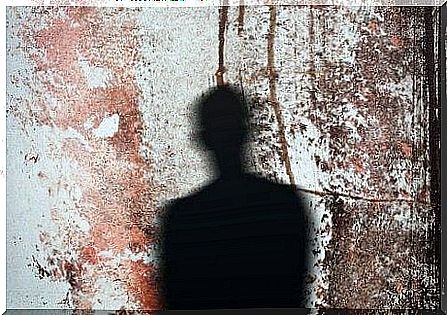 The outline of a person cast as a shadow on a wall of dried blood.