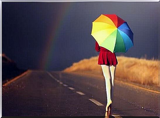 With a colorful umbrella towards the dark horizon