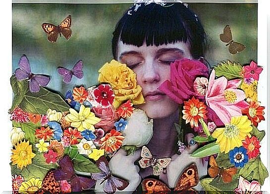 Girl with her eyes closed is surrounded by flowers