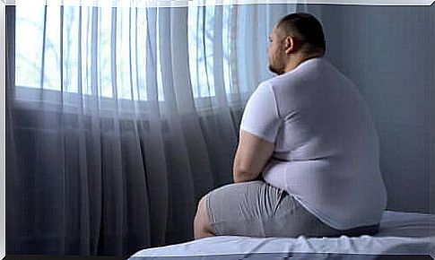 Obesity - overweight man sitting on a bed