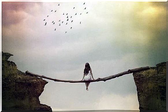 Woman sits on tree trunk and looks at the sky