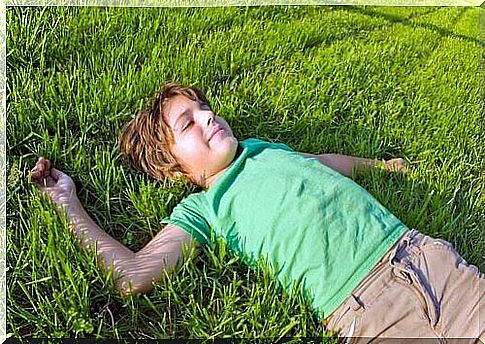 A boy is lying in the grass