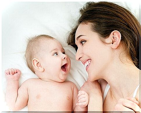 A woman and baby smile at each other, a good example of affection and attachment.