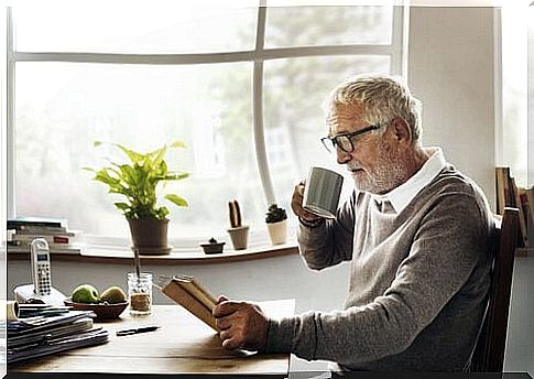 An elderly man is reading a book.