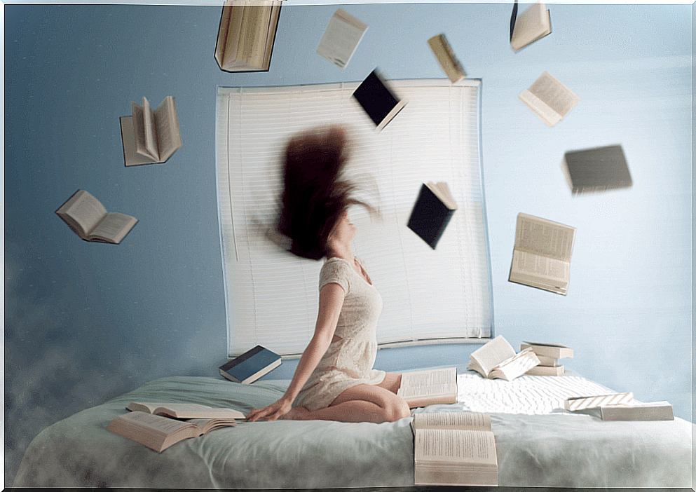 Woman in bed with books