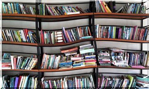 A disorganized bookshelf crammed with books