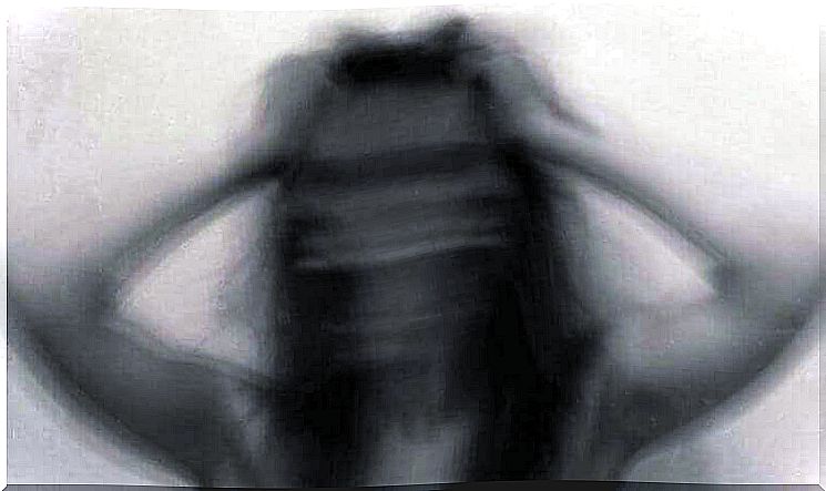 Blurred image of a woman pulling her hair with both hands.